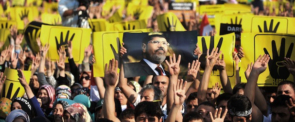 Protestors hold signs during a demonstration condemning the recent deadly military crackdown on supporters of ousted Egyptian President Mohamed Morsi protesters in Cairo on August 17, 2013, at the New Mosque in Istanbul. Turkey branded the deadly crackdown in Egypt on protesters loyal to ousted president Mohamed Morsi today as "unacceptable" and called on the international community to act immediately to halt the "massacre". AFP PHOTO/OZAN KOSE (Photo credit should read OZAN KOSE/AFP/Getty Images)