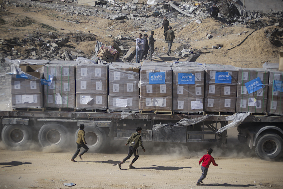 Bambini palestinesi rincorrono un camion di aiuti nel sud della Striscia di Gaza, il 22 gennaio 2025 