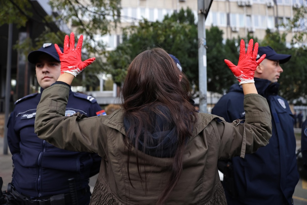 Una manifestante con le mani colorate di rosso, lo scorso 3 novembre a Belgrado 