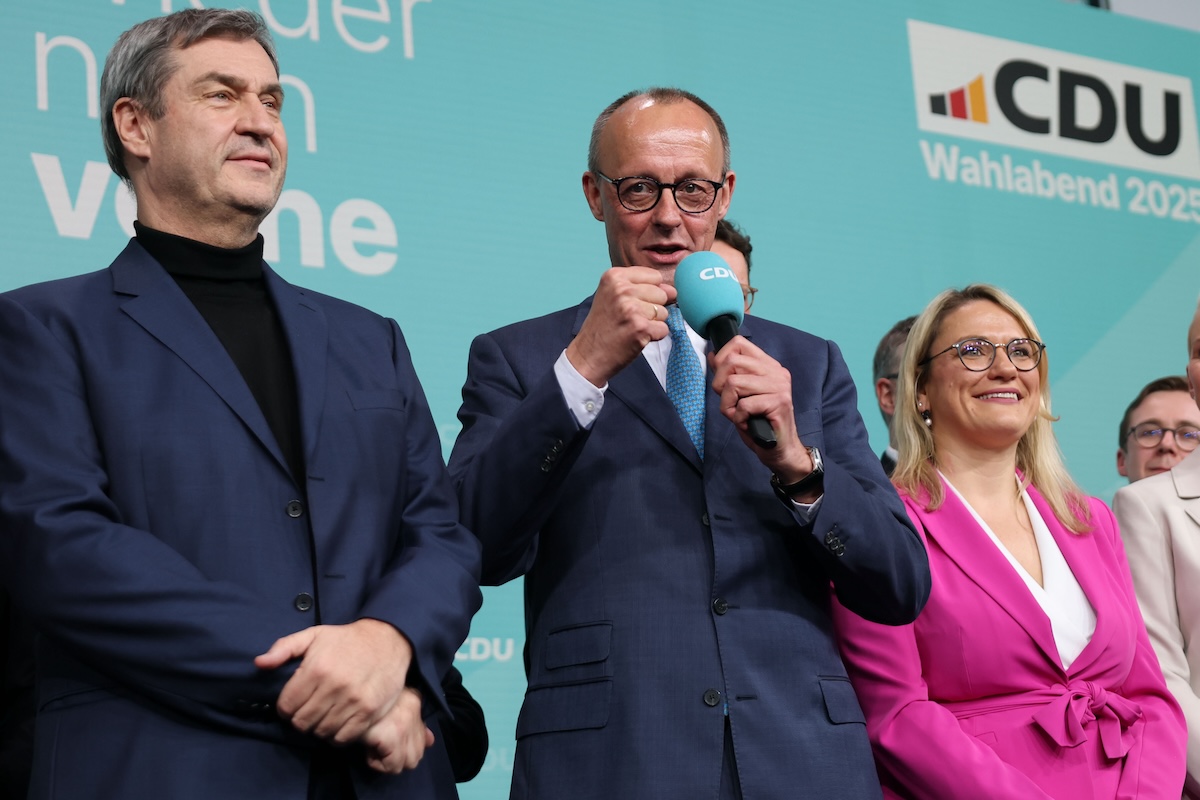 Una foto di Friedrich Merz (al centro) con una giacca con tre bottoni, Berlino, 23 febbraio 2025