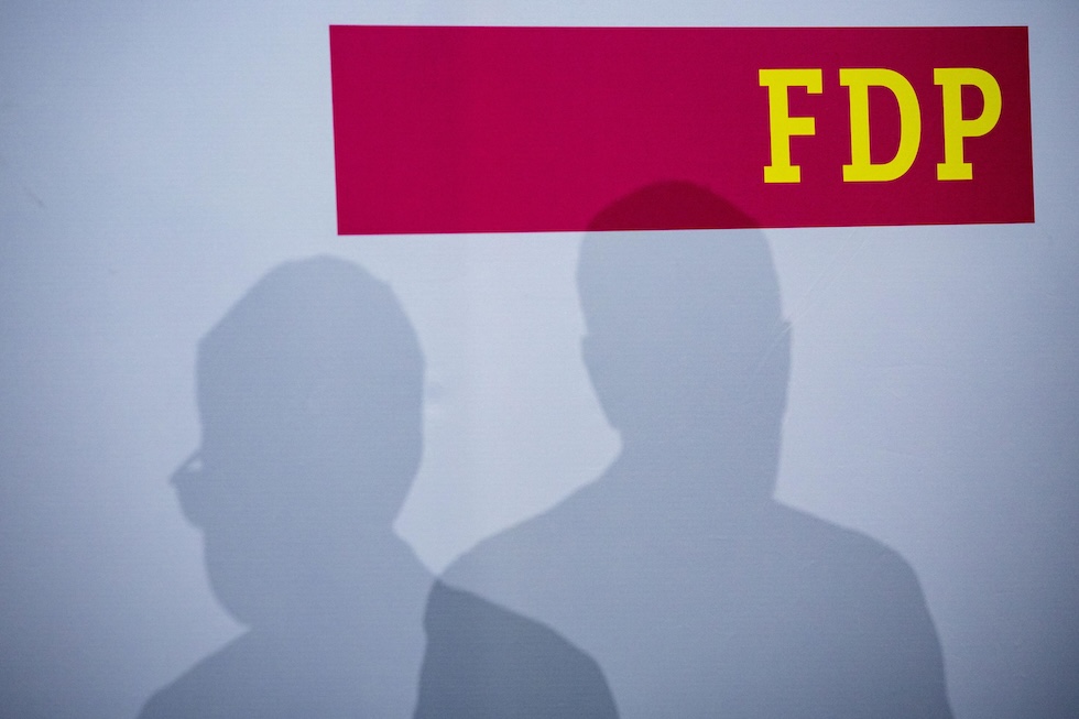 Le ombre di Christian Lindner e del segretario dei Liberali, Marco Buschmann, sul fondale della loro conferenza stampa, a Berlino il 24 febbraio 