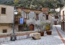 Una bandiera greca appesa al terrazzino di una casa sulla piazza centrale del borgo