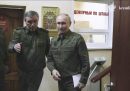 tre uomini in uniforme, fra cui vladimir putin, in un corridoio