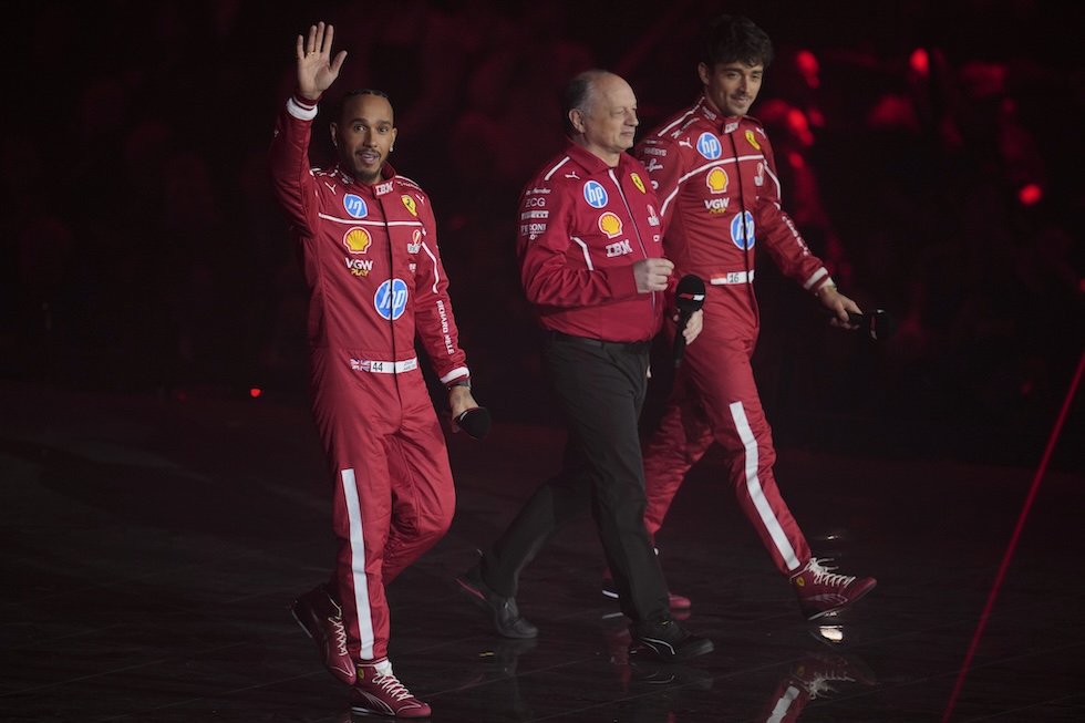 Vasseur con un microfono in mano, tra Hamilton e Leclerc in tuta da corsa