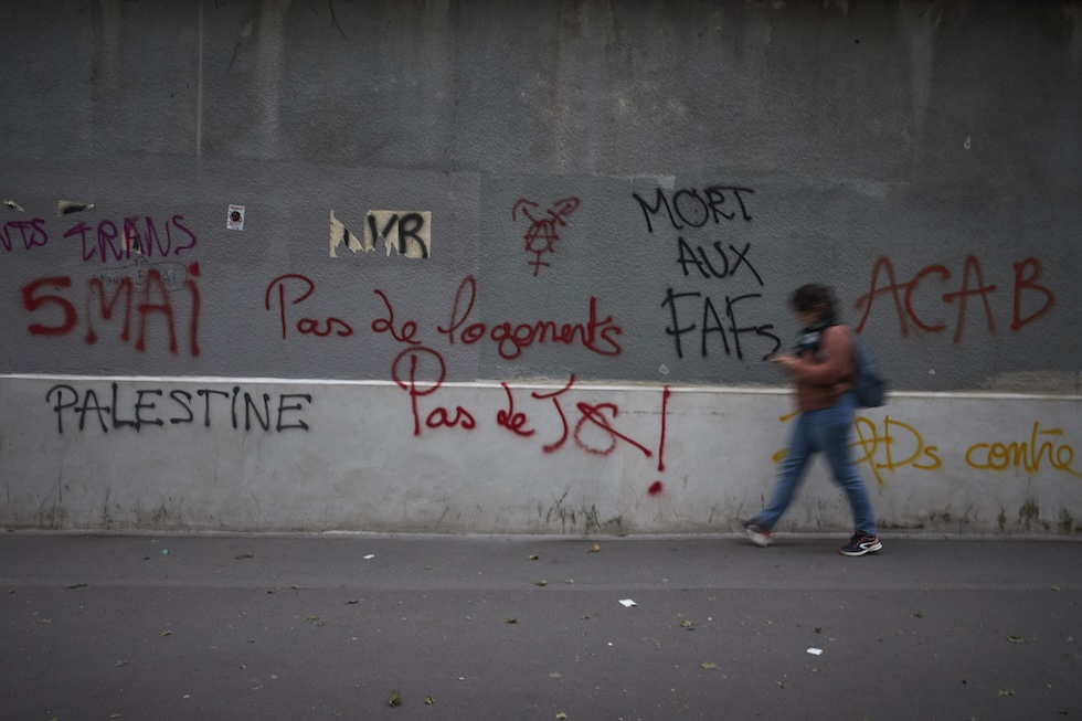 Graffiti con alcuni slogan di protesta contro le Olimpiadi dell'estate scorsa, in una via di Parigi