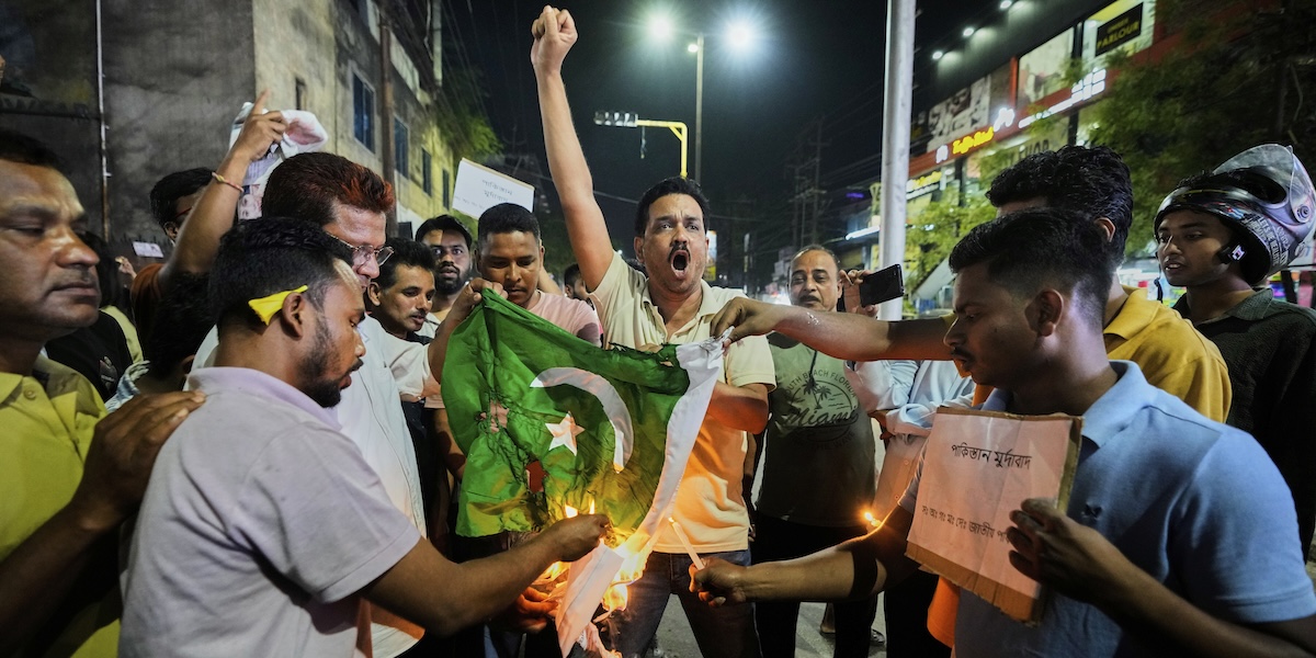Manifestanti indiani bruciano una bandiera pakistana protestando contro l'attacco armato in cui sono stati uccisi 26 turisti nel Kashmir (AP Photo/Anupam Nath)