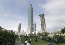 Un gruppo di persone si scatta delle foto con lo sfondo del grattacielo Taipei 101