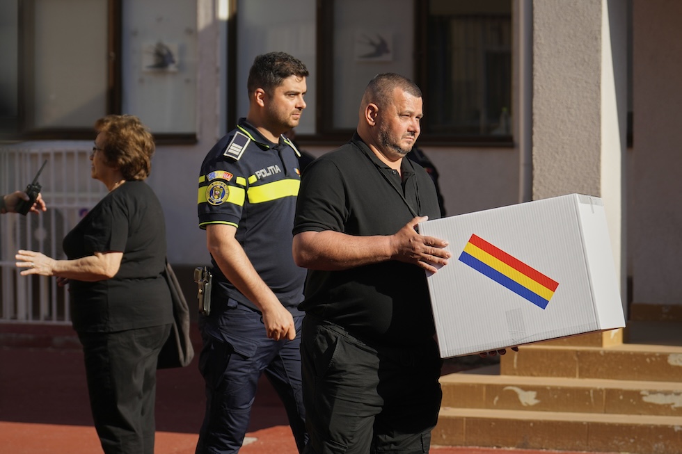 Un funzionario trasporta un'urna, domenica scorsa a Bucarest