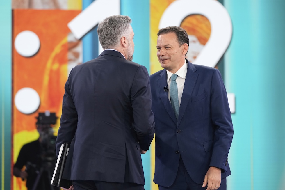 Il leader dei Socialisti, Pedro Nuno Santos, di spalle, stringe la mano a Luís Montenegro prima di un dibattito televisivo, lo scorso 30 aprile 