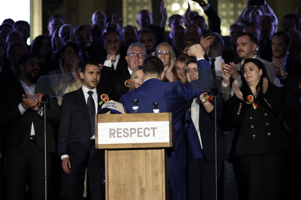 Il candidato dell'estrema destra George Simion, di spalle, arringa i sostenitori dopo la diffusione degli exit poll