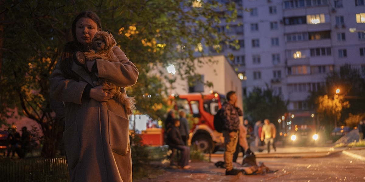 Una donna e il suo cane in una strada di Kiev colpita da un attacco con missili e droni russo, 24 maggio 2025
