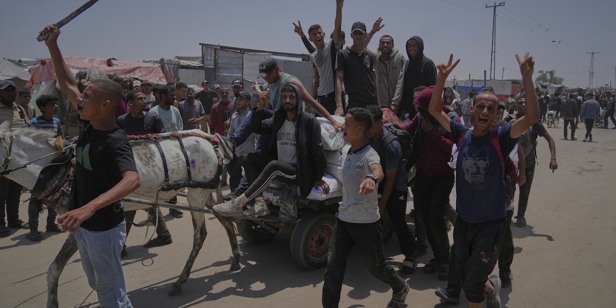 Un gruppo di palestinesi trasporta su un carro il cibo e i beni distribuiti dalla Gaza Humanitarian Foundation nel sud della Striscia di Gaza, 8 giugno 2025 (AP Photo/Abdel Kareem Hana)
