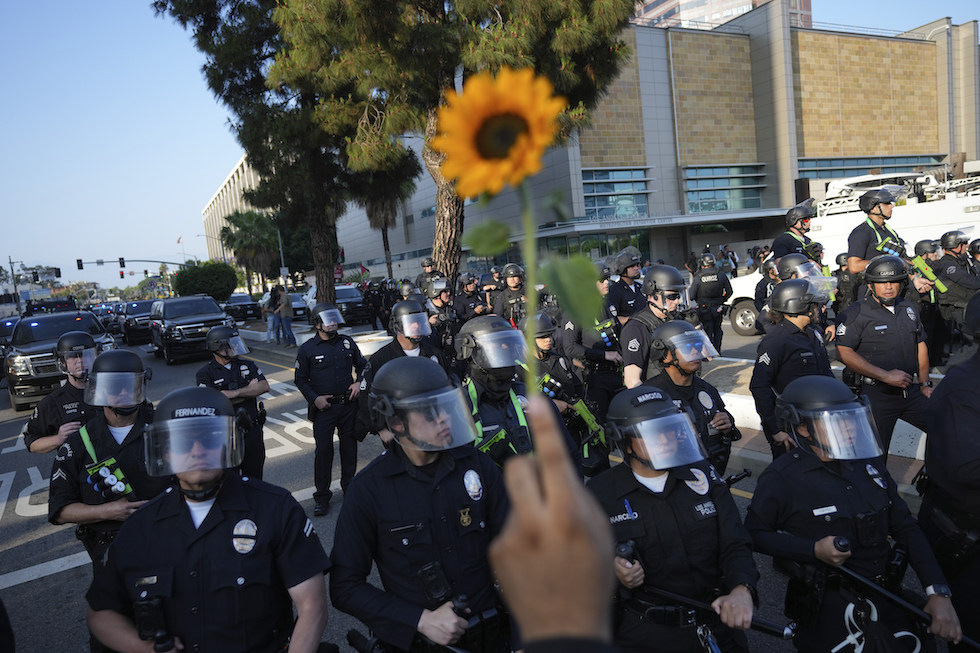 Manifestanti offrono fiori ai poliziotti a Los Angeles, 9 giugno 2025