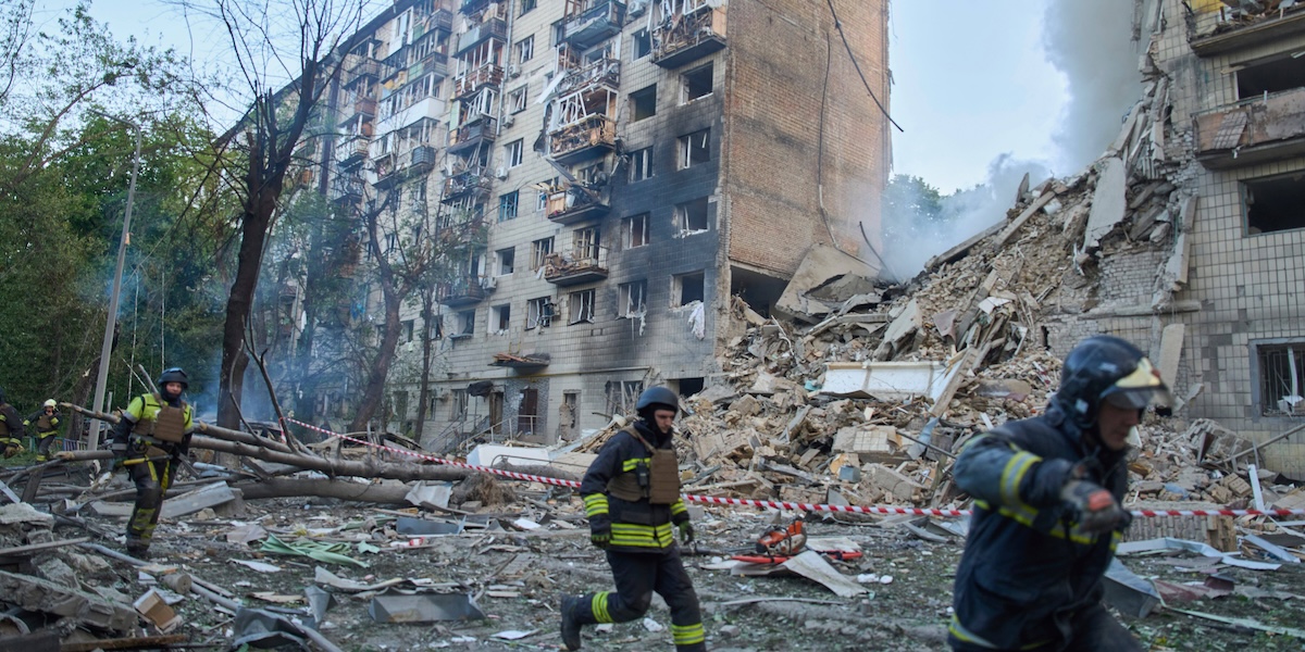 Soccorritori sul luogo di un attacco aereo a Kiev corrono a rifugiarsi durante un nuovo attacco, il 17 giugno (AP Photo/Efrem Lukatsky)