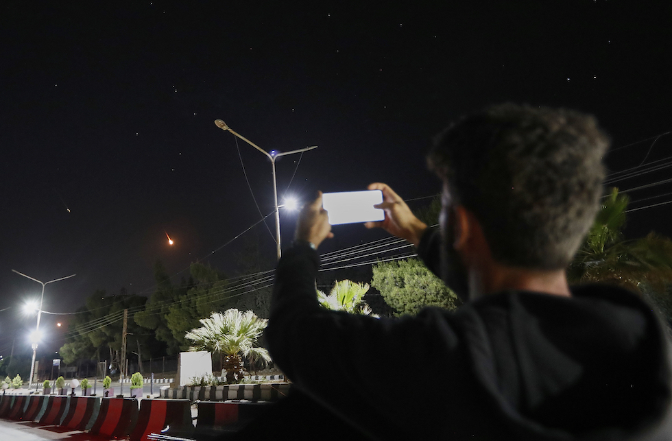 Un uomo fa foto ai missili iraniani che passano sopra la Siria diretti verso Israele, 13 maggio 2025