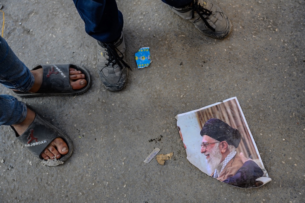 Foto di sciiti siriani che calpestano un ritratto di Khamenei durante le celebrazioni per la caduta del regime di Bashar al Assad nel dicembre 2024 (Scott Peterson /Getty Images) 