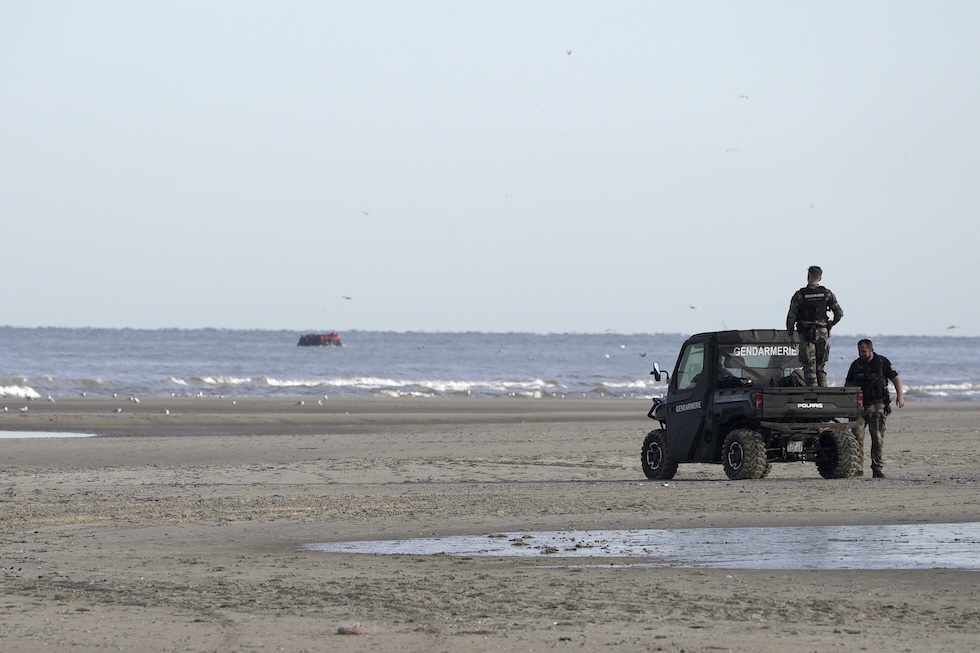 Agenti francesi osservano un'imbarcazione di migranti sulla spiaggia di Ecault, il 4 luglio