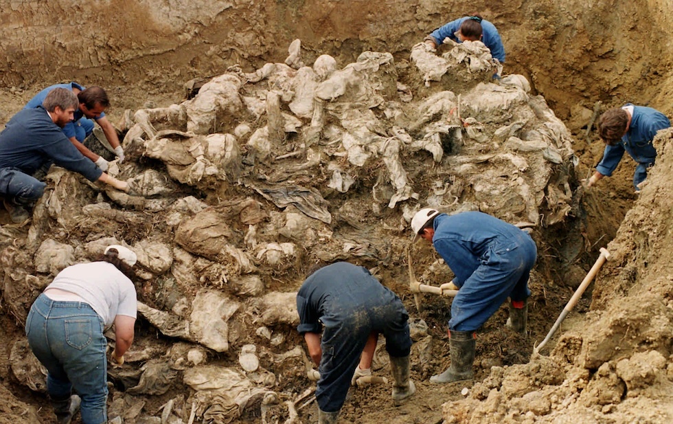 Alcuni esperti del Tribunale Penale Internazionale per l'ex Jugoslavia puliscono i resti di dozzine di vittime del genocidio di Srebrenica, in una fossa comune nel villaggio di Pilica nel 1996