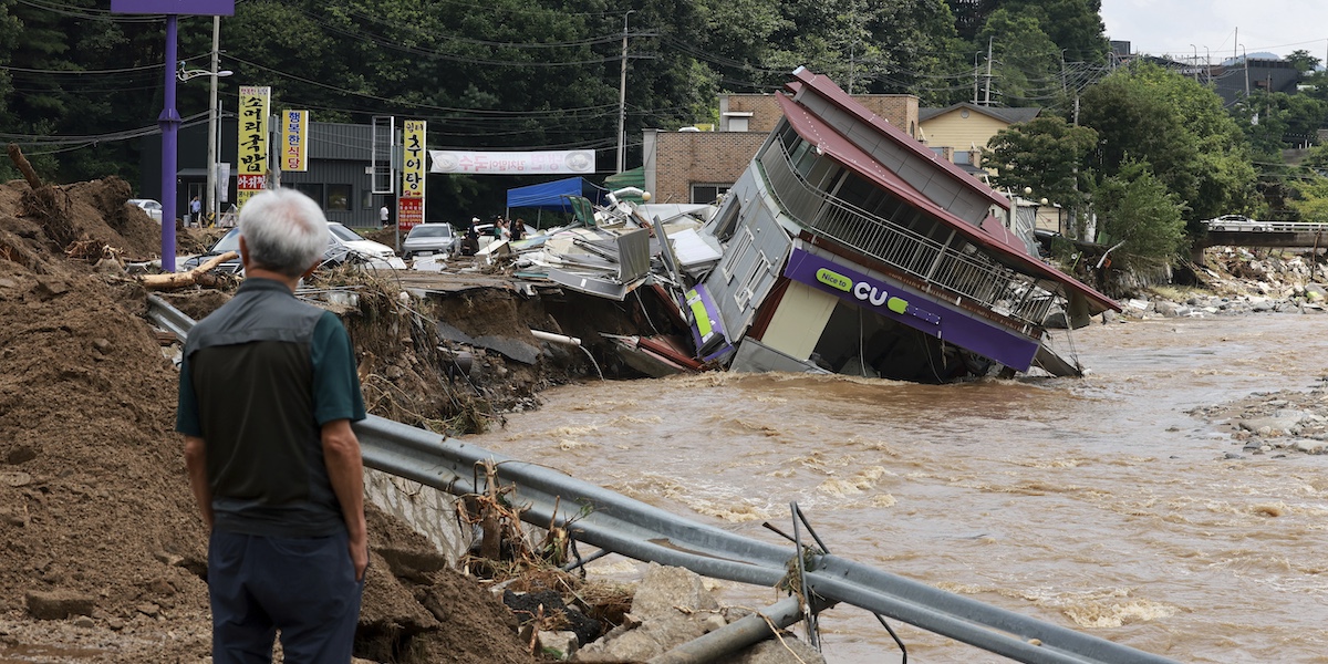 Un uomo guarda un negozio distrutto dalle piogge a Gapyeong, in Corea del Sud, il 20 luglio del 2025 (Lee Young-hwan/Newsis via AP)