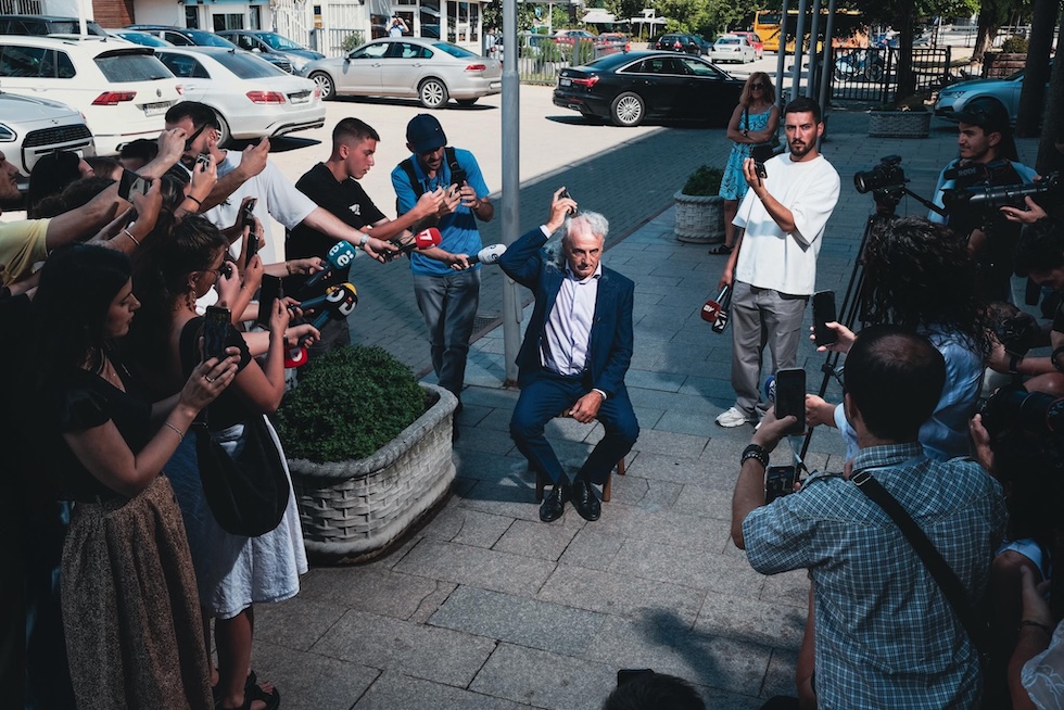 Arianit Koci si rade a zero i capelli davanti al parlamento kosovaro, per protestare contro la situazione attuale