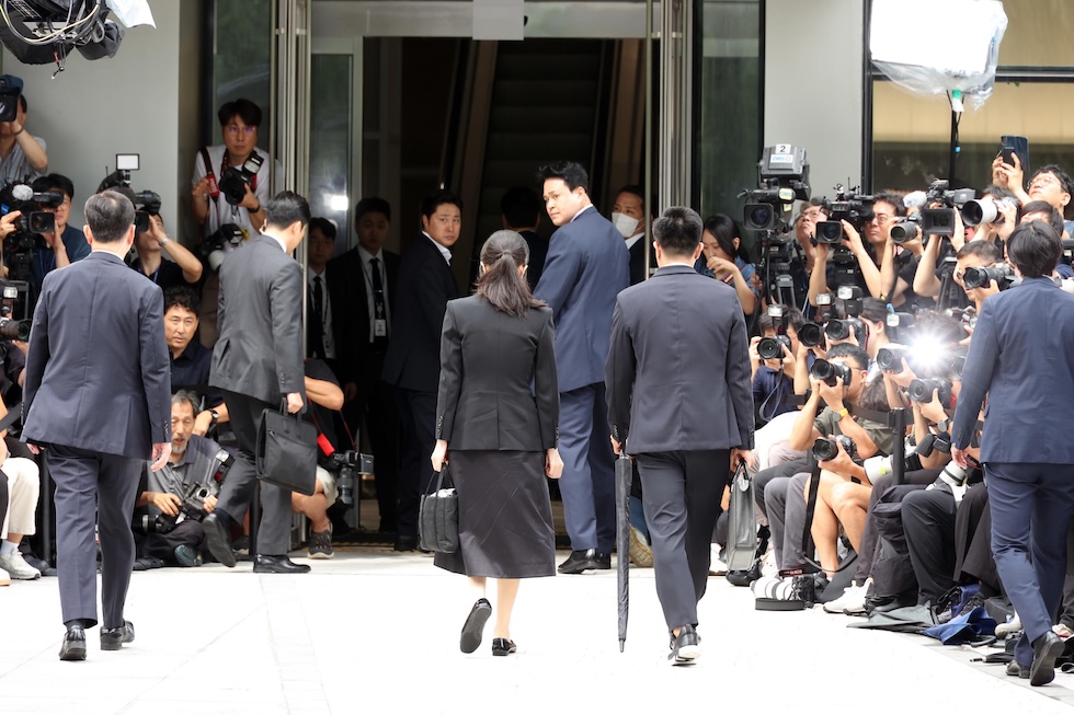 Kim Keon Hee, di spalle, arriva all'interrogatorio del 6 agosto 