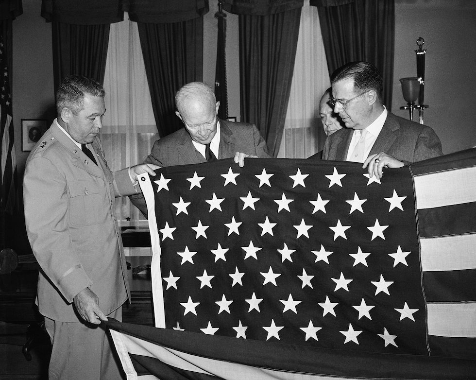L'allora presidente Dwight D. Eisenhower guarda la bandiera americana con 49 stelle, dopo l'aggiunta dell'Alaska 