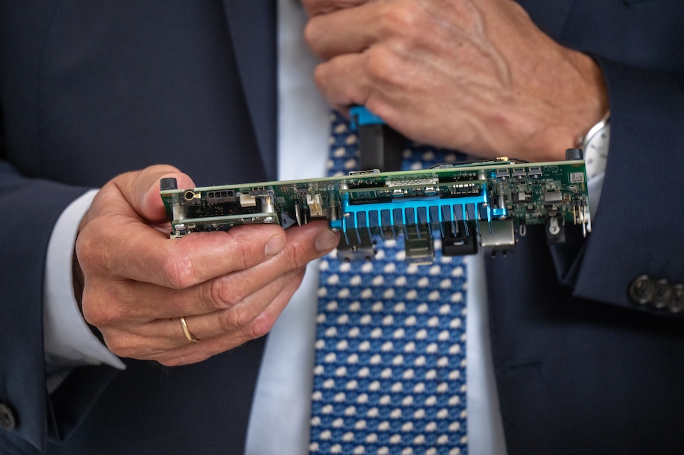 Un particolare di Merz con in mano un componente elettronico, durante la visita a una fabbrica nel Saarland, il 1° agosto 