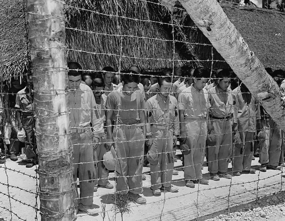 Prigionieri di guerra giapponesi detenuti a Guam chinano la testa mentre ascoltano il discorso dell'imperatore, il 15 agosto del 1945 