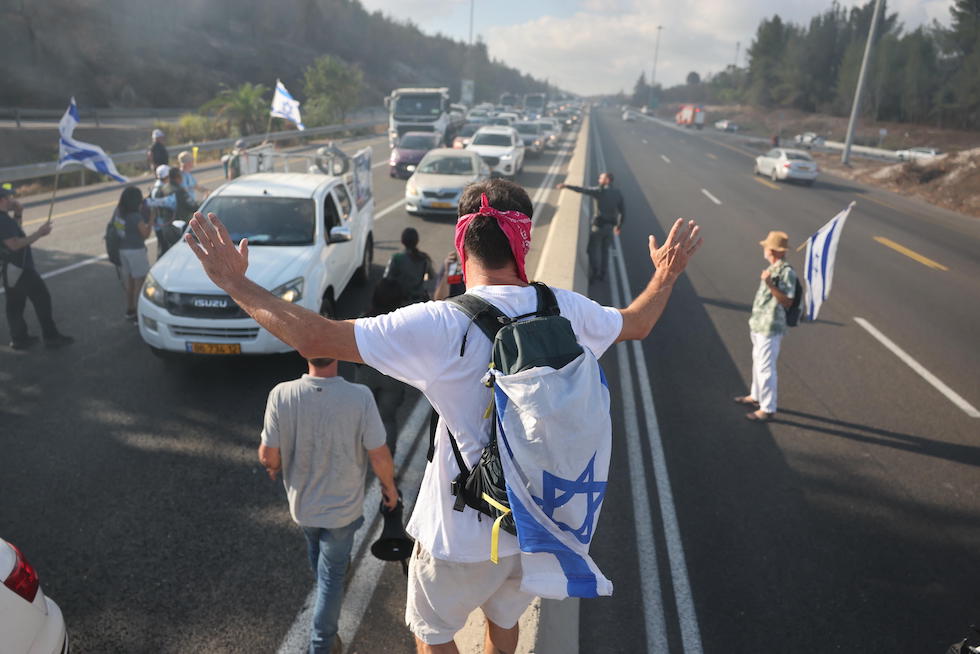 Un manifestante blocca l'autostrada che collega Tel Aviv a Gerusalemme, 17 agosto 2025