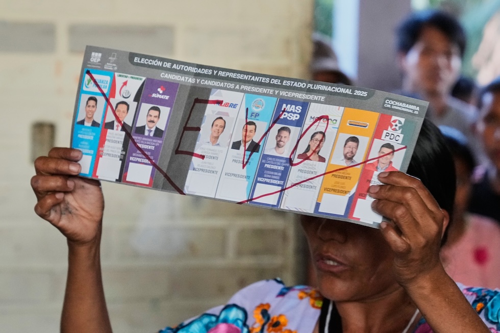 Una funzionaria mostra una scheda nulla col nome dell'ex presidente Evo Morales, a Entre Rios, il 17 agosto