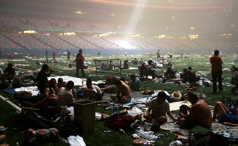La luce che filtra dal soffitto divelto del Superdome di New Orleans, in Louisiana, illumina una folla di persone che si sono riparate nello stadio durante l’uragano Katrina, 29 agosto 2005. (Michael Appleton/NY Daily News Archive via Getty Images)