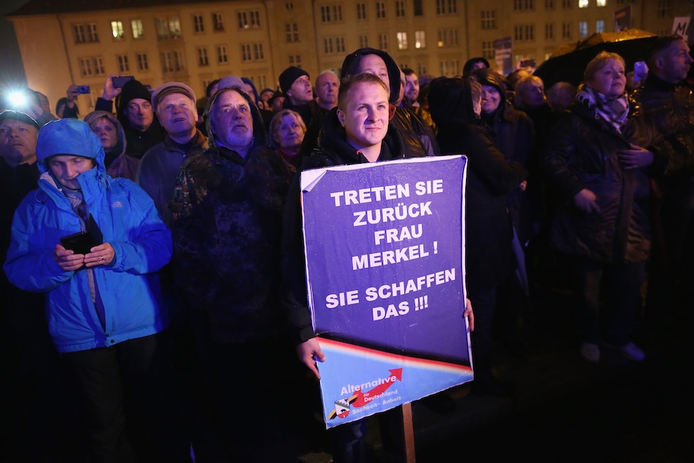 Un sostenitore del partito di estrema destra AfD a una manifestazione contro le politiche sull'asilo molto liberali del governo di Merkel, a ottobre 2015