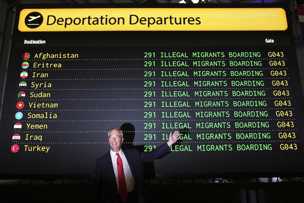 Nigel Farage presenta il piano di deportazioni di massa davanti a un finto tabellone con le partenze degli aerei, il 26 agosto 
