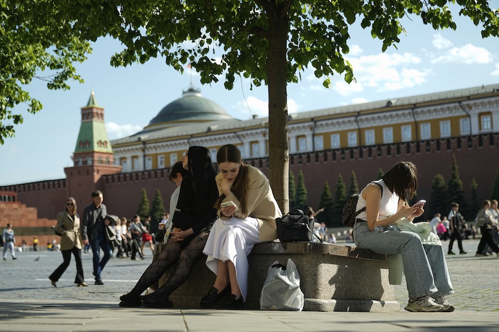Alcune persone guardano i propri telefoni cellulari nella Piazza Rossa, a Mosca