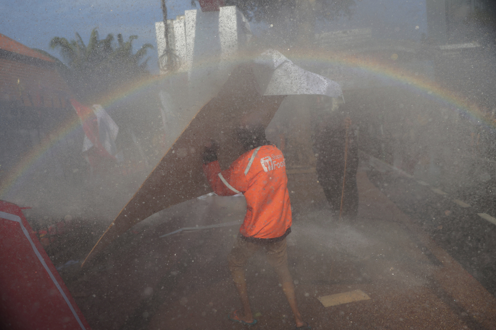 Un manifestante si difende dagli idranti usati dalla polizia in Indonesia, 29 agosto 2025