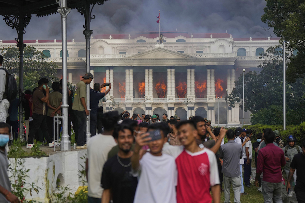 Manifestanti si fanno un selfie davanti al palazzo del governo in Nepal, 9 settembre 2025