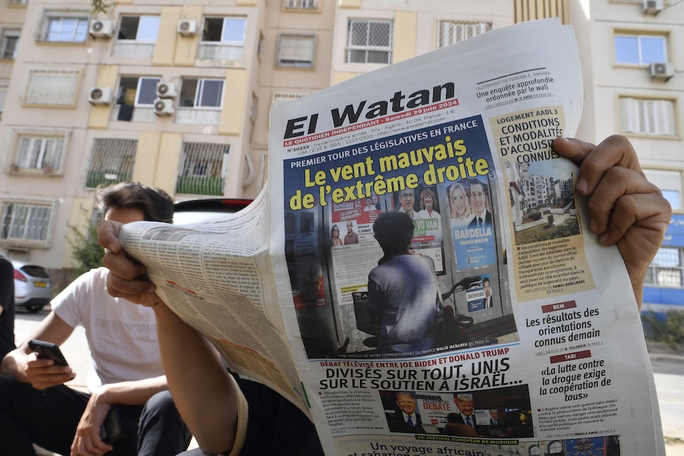 Un uomo legge una copia di Al Watan, un giornale francofono algerino, ad Algeri, nell'estate del 2024 (AP Photo/Fateh Guidoum)