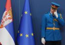 Un membro della guardia d'onore serba accanto a una bandiera dell'Unione Europea e a una della Serbia prima della visita della presidente della Commissione europea Ursula von der Leyen al palazzo di Serbia