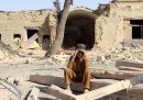 Un bambino è seduto davanti alla sua casa distrutta, con le mani sulla fronte. Dietro di lui l'abitazione crollata a causa degli scontri al confine tra Pakistan e Afghanistan.