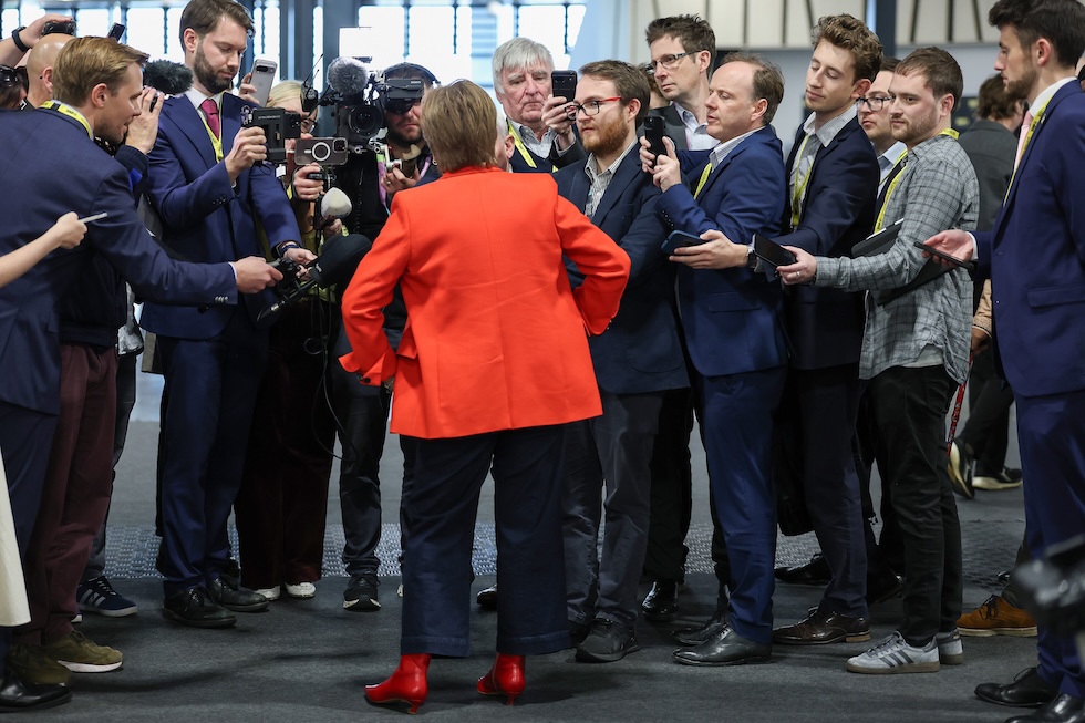 L'ex leader del partito Nicola Sturgeon, di spalle, parla coi giornalisti durante la convention, il 12 ottobre 