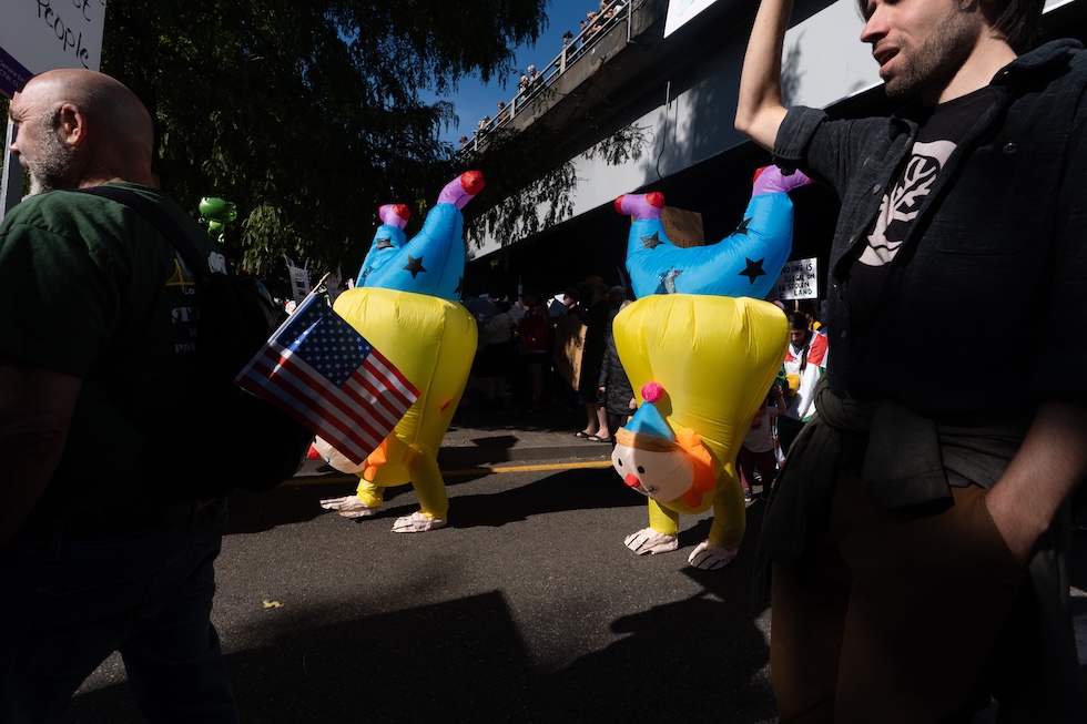 Due persone con costumi gonfiabili da clown durante la manifestazione No Kings a Portland, in Oregon, il 18 ottobre 2025