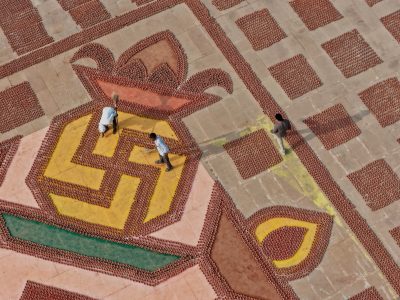 Delle persone puliscono il pavimento su cui c'è il simbolo geometrico delle lampade del Deepotsav: lampade di argilla usate per illuminare la città di Ayodhya e le rive del fiume Saryu durante le celebrazioni del Diwali, il festival delle luci