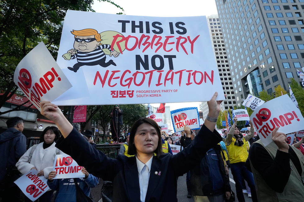 Una manifestazione contro Trump in Corea del Sud, 25 ottobre 2025. Sul cartello c'è scritto: «Questa è una rapina, non un negoziato»