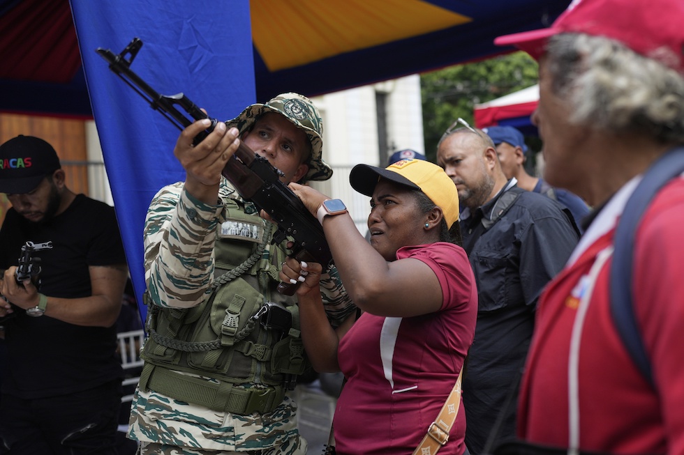 Un militare venezuelano mostra a una donna come usare un fucile a Caracas, settembre 2025
