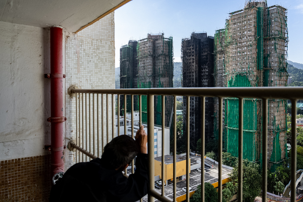 Una donna guarda i palazzi incendiati, 28 novembre 2025