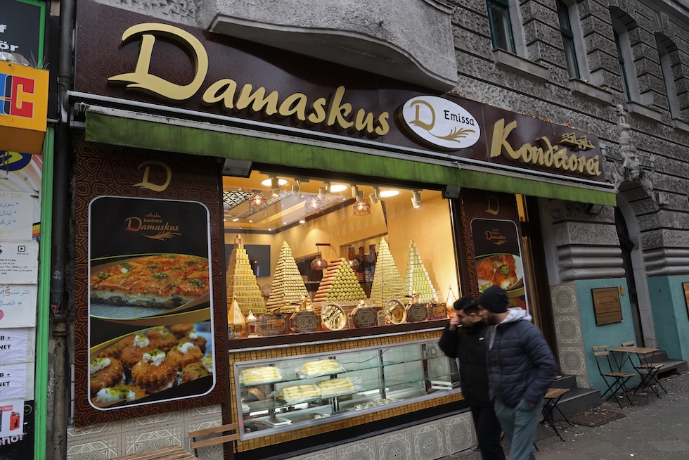 L'esterno di una pasticceria siriana nel distretto di Neukoelln, a Berlino, uno di quelli dove c'è una maggiore presenza di persone immigrate.