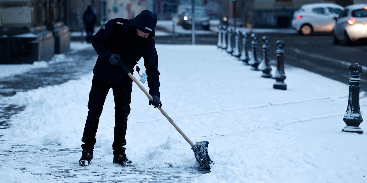 Un uomo spala la neve a Lille, il 7 gennaio
