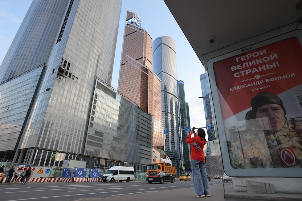 Una donna scatta una foto a un edificio danneggiato