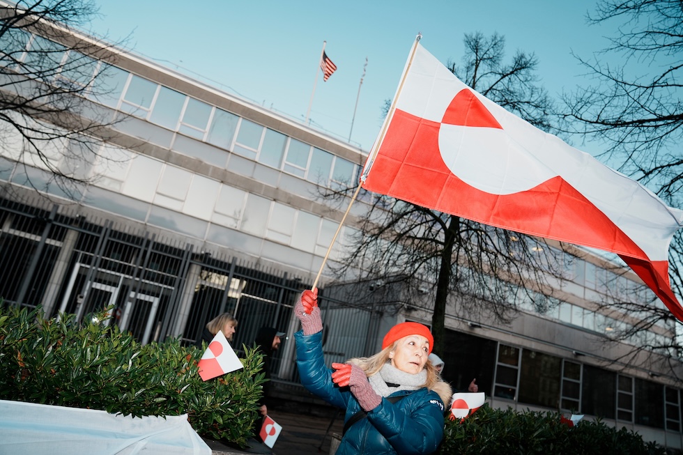 Una manifestante con la bandiera della Groenlandia durante la protesta davanti all'ambasciata statunitense a Copenhagen, mercoledì 14 gennaio (AP/Ritzau Scanpix/Thomas Traasdahl)