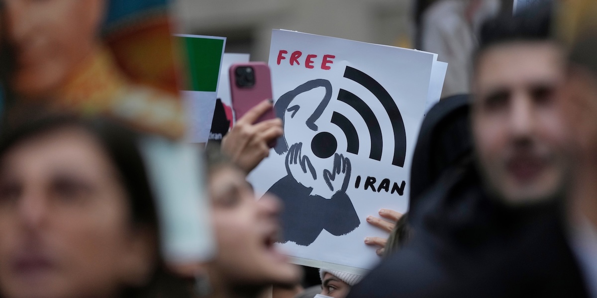 Alcune persone durante una mobilitazione a sostegno dei manifestanti iraniani davanti al Consolato dell'Iran a Milano, 13 gennaio 2026 (AP Photo/Luca Bruno)